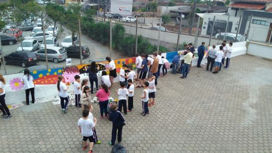 Cooperação entre alunos para colorir com arte o muro da Escola Albano Kanzler