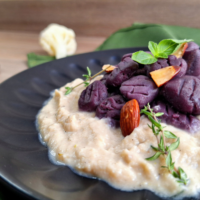 Nhoque de batata roxa ao molho bechamel vegano